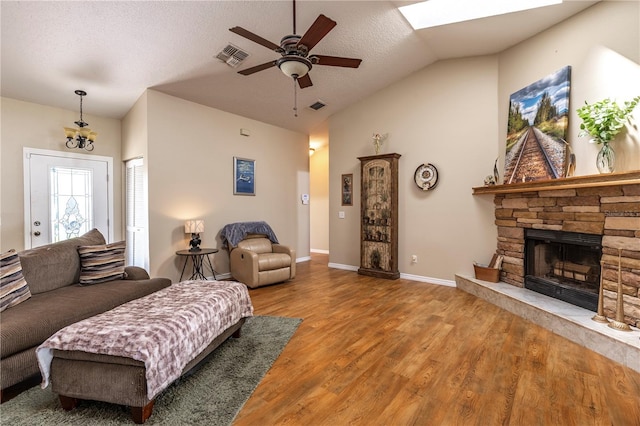 5521 Oak St, Mount Dora, FL 32757 - living area featuring lofted ceiling, ceiling fan, wood finished floors, a stone fireplace, and baseboards