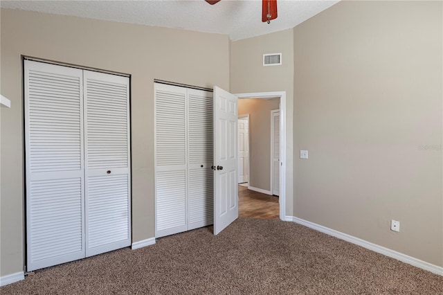 5521 Oak St, Mount Dora, FL 32757 - unfurnished bedroom featuring carpet flooring, two closets, baseboards, and high vaulted ceiling