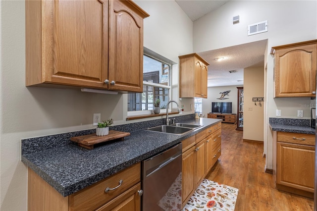 5521 Oak St, Mount Dora, FL 32757 - kitchen featuring stainless steel dishwasher, a sink, light wood-type flooring, dark countertops, and a towering ceiling