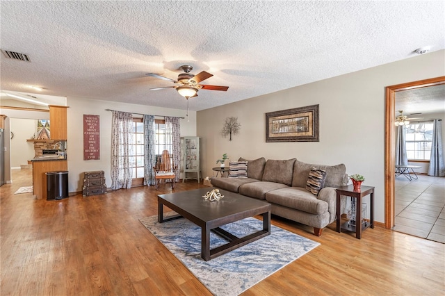 5521 Oak St, Mount Dora, FL 32757 - living area featuring ceiling fan, a textured ceiling, light wood finished floors, and baseboards