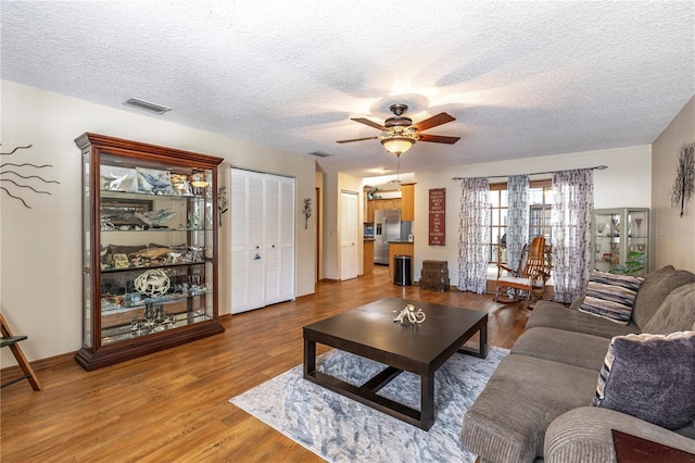5521 Oak St, Mount Dora, FL 32757 - living area featuring a textured ceiling, a ceiling fan, and wood finished floors
