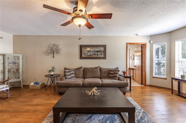 5521 Oak St, Mount Dora, FL 32757 - living area featuring light wood-style flooring, a textured ceiling, a ceiling fan, and baseboards