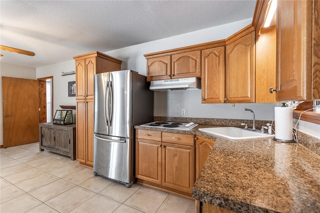5521 Oak St, Mount Dora, FL 32757 - kitchen with under cabinet range hood, freestanding refrigerator, a sink, ceiling fan, and brown cabinets