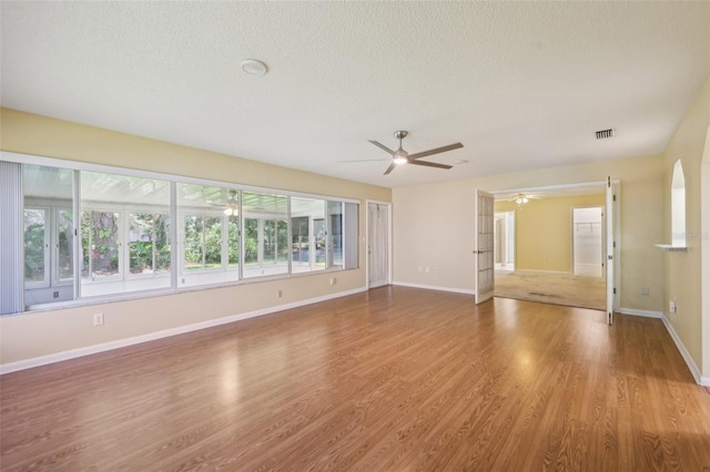 1011 Dundee Cir, Leesburg, FL 34788 - empty room featuring ceiling fan, a textured ceiling, wood finished floors, and baseboards