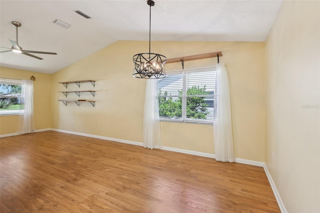 1011 Dundee Cir, Leesburg, FL 34788 - empty room with vaulted ceiling, a ceiling fan, a chandelier, light wood finished floors, and baseboards