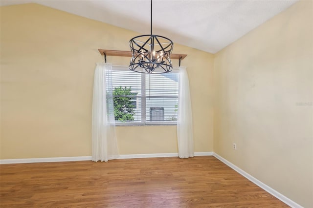 1011 Dundee Cir, Leesburg, FL 34788 - unfurnished room featuring lofted ceiling, a chandelier, wood finished floors, and baseboards