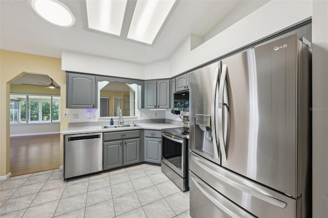 1011 Dundee Cir, Leesburg, FL 34788 - kitchen with appliances with stainless steel finishes, gray cabinets, arched walkways, and a sink