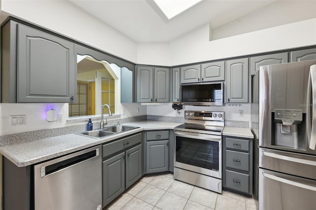1011 Dundee Cir, Leesburg, FL 34788 - kitchen with appliances with stainless steel finishes, gray cabinetry, a sink, light tile patterned floors, and light countertops