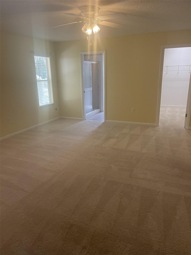 1011 Dundee Cir, Leesburg, FL 34788 - empty room with light colored carpet, ceiling fan, baseboards, and a textured ceiling