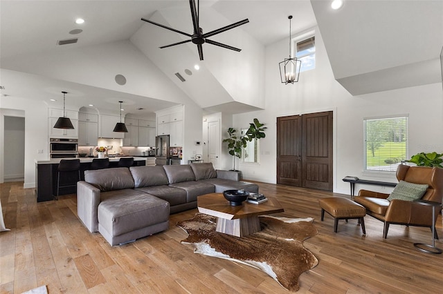 35449 Pinegate Trl, Eustis, FL 32736 - living room featuring high vaulted ceiling, light wood-type flooring, a ceiling fan, healthy amount of natural light, and recessed lighting