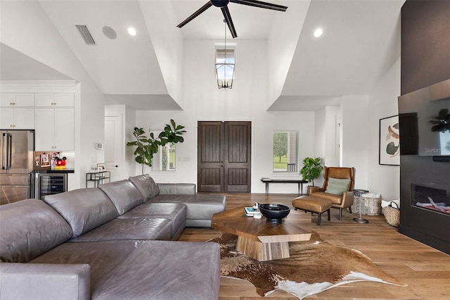 35449 Pinegate Trl, Eustis, FL 32736 - living room with high vaulted ceiling, beverage cooler, ceiling fan, light wood finished floors, and bar area