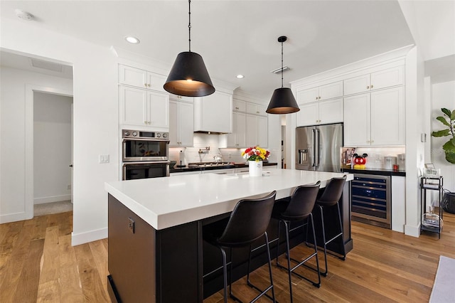 35449 Pinegate Trl, Eustis, FL 32736 - kitchen featuring wine cooler, appliances with stainless steel finishes, tasteful backsplash, white cabinetry, and recessed lighting