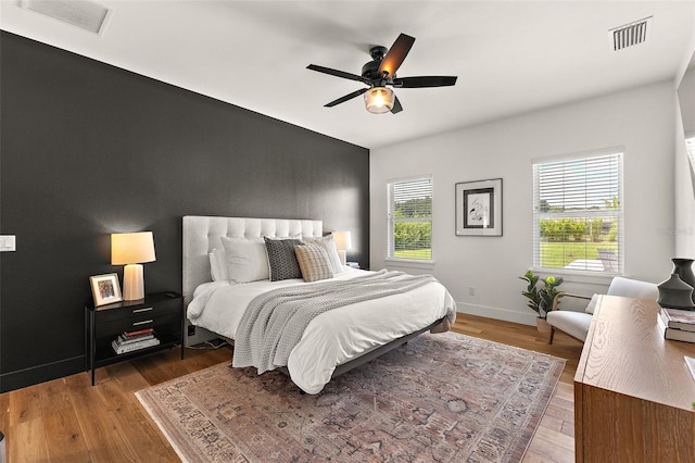 35449 Pinegate Trl, Eustis, FL 32736 - bedroom with wood finished floors, an accent wall, and a ceiling fan