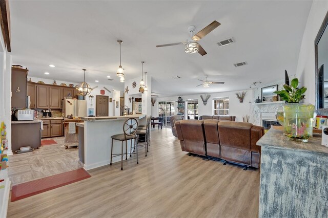 21320 Paradise Way, Eustis, FL 32736 - living room with ceiling fan, recessed lighting, light wood-style flooring, a glass covered fireplace, and a chandelier