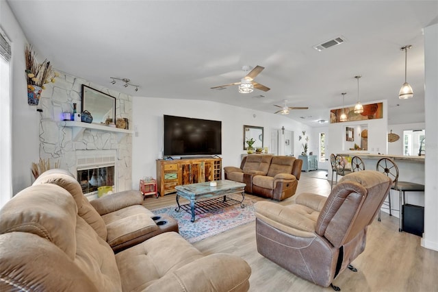 21320 Paradise Way, Eustis, FL 32736 - living room featuring light wood finished floors, a ceiling fan, and a stone fireplace