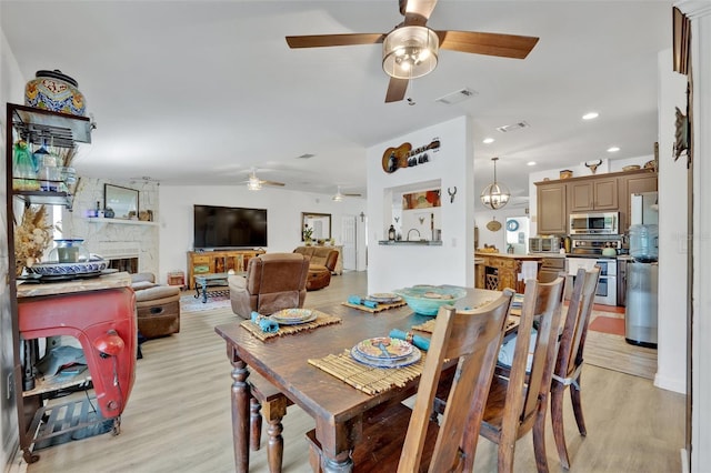 21320 Paradise Way, Eustis, FL 32736 - dining space with a ceiling fan, light wood-type flooring, a fireplace, and recessed lighting