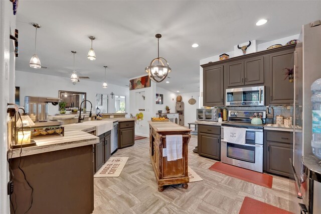 21320 Paradise Way, Eustis, FL 32736 - kitchen with stainless steel appliances, gray cabinets, a kitchen island, a chandelier, and decorative backsplash