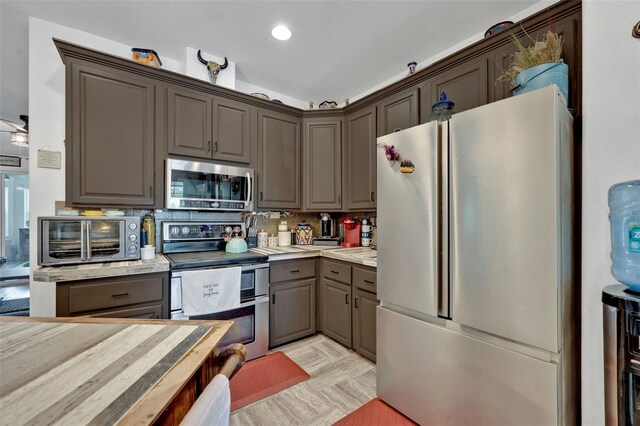 21320 Paradise Way, Eustis, FL 32736 - kitchen with stainless steel appliances, light countertops, decorative backsplash, gray cabinetry, and recessed lighting