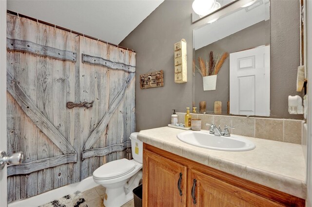 21320 Paradise Way, Eustis, FL 32736 - bathroom with vanity, toilet, tile patterned flooring, vaulted ceiling, and a shower with curtain
