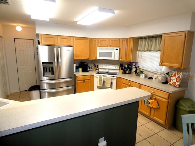 751 Old Oaks Ln, Leesburg, FL 34748 - kitchen with white appliances, light tile patterned floors, light countertops, and brown cabinets