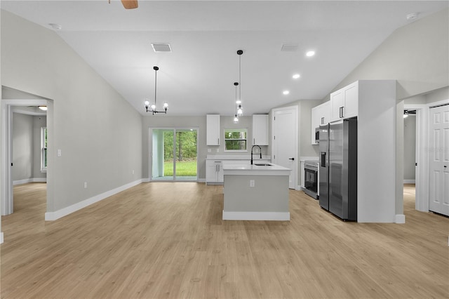 1115 W Geneva Pl, Citrus Springs, FL 34434 - kitchen featuring stainless steel fridge, vaulted ceiling, light countertops, a sink, and an island with sink