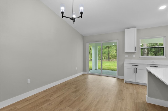 1115 W Geneva Pl, Citrus Springs, FL 34434 - unfurnished dining area with plenty of natural light, light wood-style flooring, baseboards, vaulted ceiling, and recessed lighting