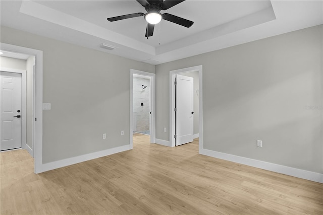 1115 W Geneva Pl, Citrus Springs, FL 34434 - empty room featuring a tray ceiling, baseboards, light wood-style flooring, and ceiling fan