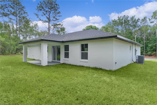 1115 W Geneva Pl, Citrus Springs, FL 34434 - back of property with cooling unit, a shingled roof, a yard, stucco siding, and a patio area