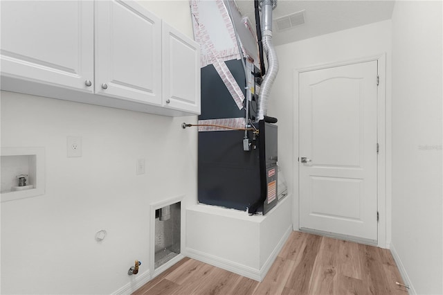 1313 Arredondo Dr, The Villages, FL 32162 - laundry room with cabinet space, light wood-style floors, washer hookup, baseboards, and heating unit
