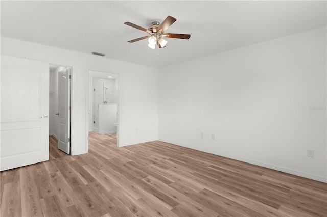 1313 Arredondo Dr, The Villages, FL 32162 - unfurnished bedroom featuring light wood-style flooring, ceiling fan, baseboards, connected bathroom, and a walk in closet