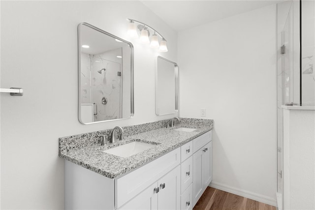 1313 Arredondo Dr, The Villages, FL 32162 - bathroom with wood finished floors, a marble finish shower, double vanity, and baseboards