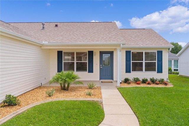 1313 Arredondo Dr, The Villages, FL 32162 - property entrance featuring a yard, roof with shingles, and covered porch
