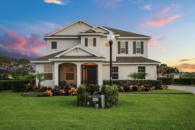 17700 Sawgrass Run, Tavares, FL 32778 - traditional-style house featuring a shingled roof, stucco siding, and a front lawn