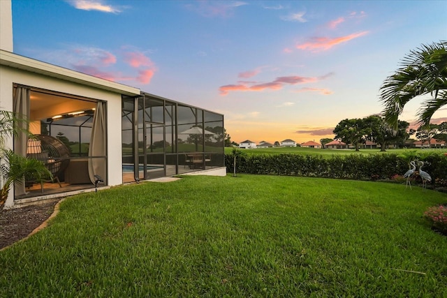 17700 Sawgrass Run, Tavares, FL 32778 - yard at dusk with a lawn, a lanai, and an outdoor pool