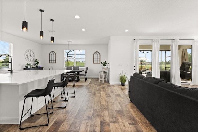 17700 Sawgrass Run, Tavares, FL 32778 - kitchen with wood finished floors, recessed lighting, hanging light fixtures, light countertops, and open floor plan