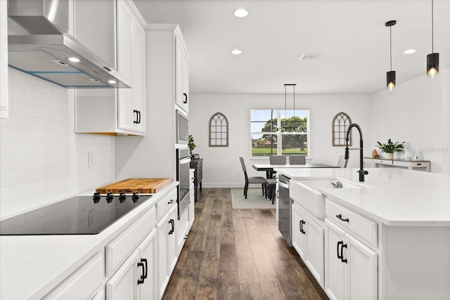 17700 Sawgrass Run, Tavares, FL 32778 - kitchen featuring appliances with stainless steel finishes, wall chimney exhaust hood, dark wood-type flooring, recessed lighting, and light countertops