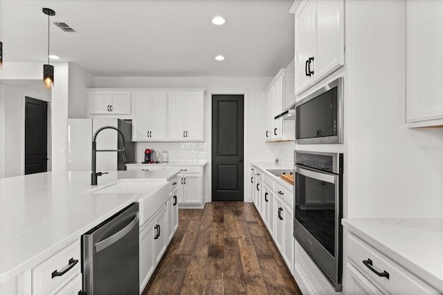 17700 Sawgrass Run, Tavares, FL 32778 - kitchen with stainless steel appliances, recessed lighting, decorative backsplash, white cabinets, and dark wood-type flooring