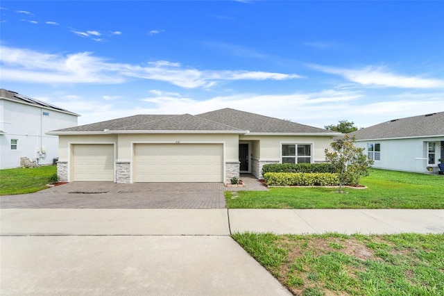 641 Black Eagle Dr, Groveland, FL 34736 - view of front of home with driveway, an attached garage, stucco siding, a front yard, and stone siding