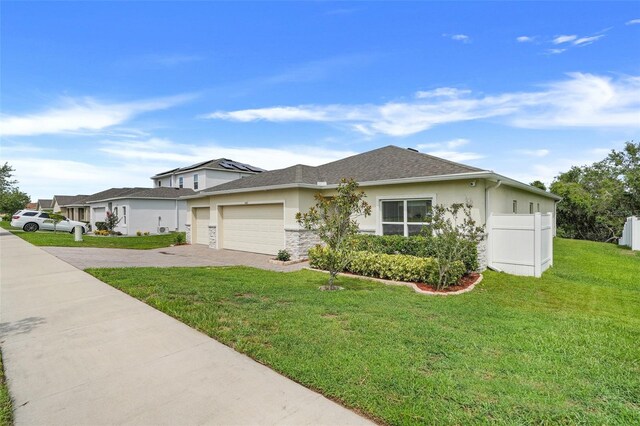 641 Black Eagle Dr, Groveland, FL 34736 - view of front of home with a garage, driveway, a front lawn, stucco siding, and stone siding