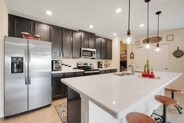 641 Black Eagle Dr, Groveland, FL 34736 - kitchen featuring stainless steel appliances, a sink, a breakfast bar area, light countertops, and an island with sink