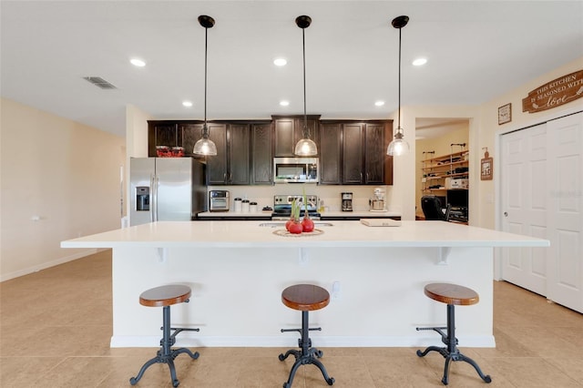 641 Black Eagle Dr, Groveland, FL 34736 - kitchen featuring appliances with stainless steel finishes, light countertops, a large island, a kitchen breakfast bar, and recessed lighting