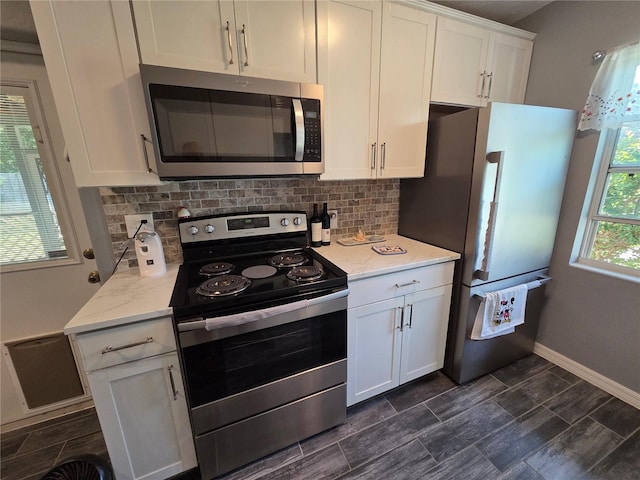 504 SE 35th Ave, Ocala, FL 34471 - kitchen featuring appliances with stainless steel finishes, backsplash, white cabinetry, and baseboards