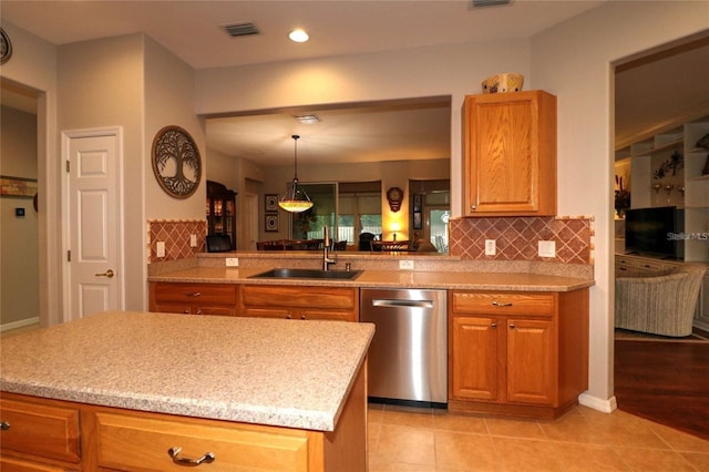 11868 SE 91st Cir, Summerfield, FL 34491 - kitchen with stainless steel dishwasher, a sink, backsplash, decorative light fixtures, and brown cabinets