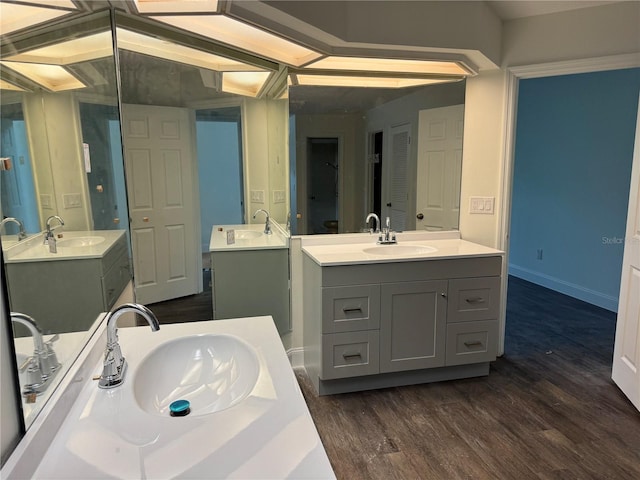 2450 Sweetwater Country Club Dr, Apopka, FL 32712 - bathroom with two vanities, wood finished floors, and baseboards