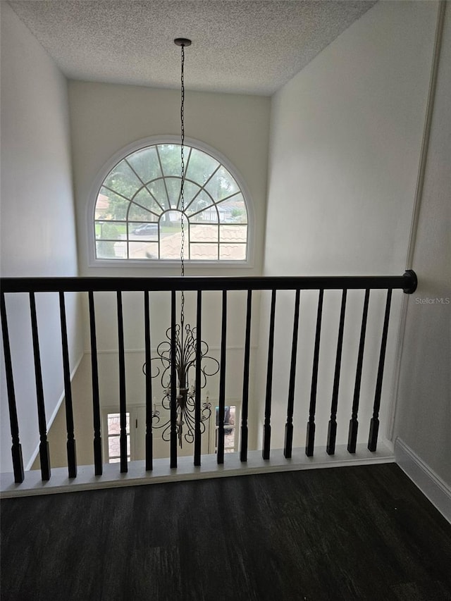 2450 Sweetwater Country Club Dr, Apopka, FL 32712 - stairway with a chandelier, wood finished floors, healthy amount of natural light, and a textured ceiling