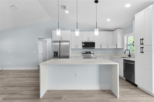 472 Malauka Radl, Ocklawaha, FL 32179 - kitchen with stainless steel appliances, a center island, light countertops, white cabinetry, and vaulted ceiling