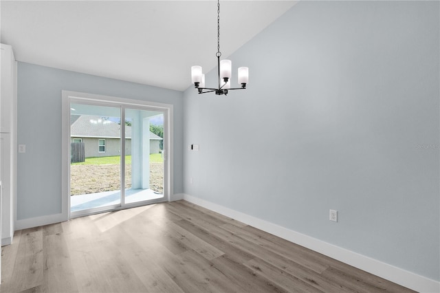 472 Malauka Radl, Ocklawaha, FL 32179 - unfurnished dining area featuring a chandelier, wood finished floors, lofted ceiling, and baseboards
