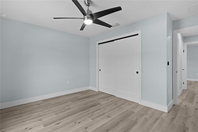 472 Malauka Radl, Ocklawaha, FL 32179 - unfurnished bedroom with light wood-style floors, a closet, baseboards, and a ceiling fan