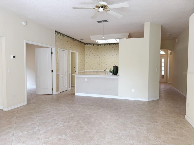 3555 Chapel Hill Blvd, Clermont, FL 34711 - unfurnished living room featuring ceiling fan, light tile patterned floors, arched walkways, baseboards, and a sink