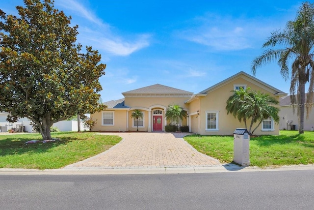 5556 Vintage View Blvd, Lakeland, FL 33812 - mediterranean / spanish-style house featuring decorative driveway, stucco siding, and a front lawn